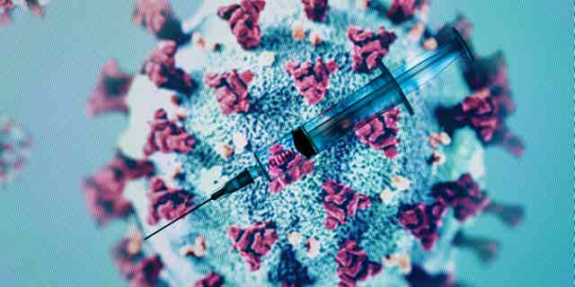 A syringe is pictured on an illustration representation of the coronavirus.