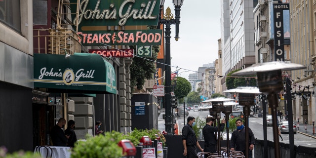 Workers assemble a heater in an outdoor dining area at a restaurant in San Francisco, California, U.S., on Wednesday, Aug. 5, 2020. Photographer: David Paul Morris/Bloomberg
