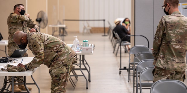 Soldiers file paperwork before being administered their COVID-19 vaccinations by Army Preventative Medical Services Sept. 9, 2021, at Fort Knox, Kentucky. 