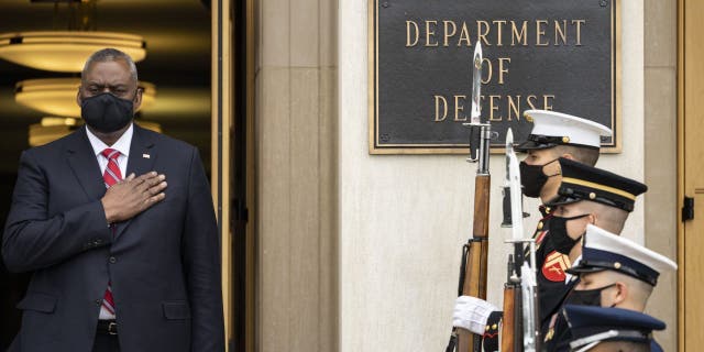 Secretary of Defense Lloyd Austin stands for the national anthem.