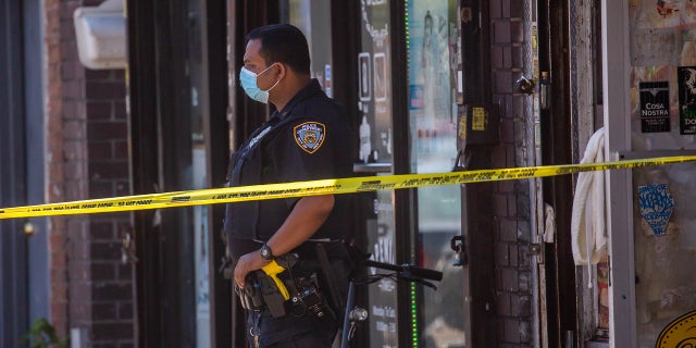 An NYPD officer monitors a crime scene in New York City. 