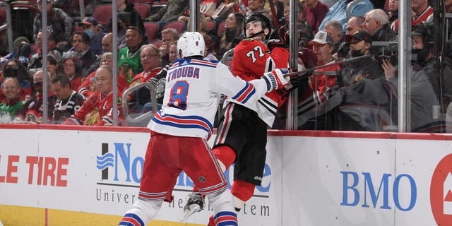 芝加哥, ILLINOIS - 十二月 07: Kirby Dach #77 of the Chicago Blackhawks is hit by Jacob Trouba #8 of the New York Rangers in the third period at United Center on December 07, 2021 在芝加伊利诺伊州ois.