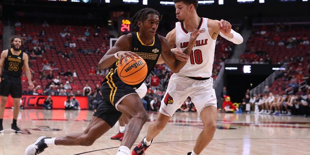 Southeastern Louisiana Lions forward Jalyn Hinton (0) drives past Louisville Cardinals forward Samuell Williamson (10) during a mens college basketball game between the SE Louisiana Lions and Louisville Cardinals on December 14, 2021 at the KFC Yum! Center, in Louisville, KY. 