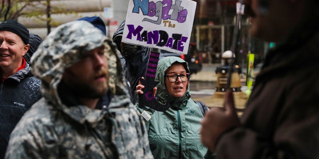 Fraternal Order of Police members, city workers and supporters rally against a vaccine mandate outside Chicago City Hall ahead of a City Council meeting on Oct 25, 2021, in Chicago.