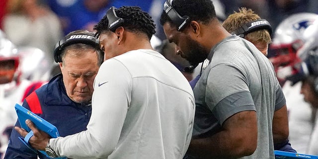 New England Patriots head coach Bill Belichick huddled with his defense coaches after the Colts scoring drive in the first quarter. The Indianapolis Colts host the New England Patriots on Dec. 18, 2021 in a Saturday night NFL game at Lucas Oil Stadium in Indianapolis, Indiana. 