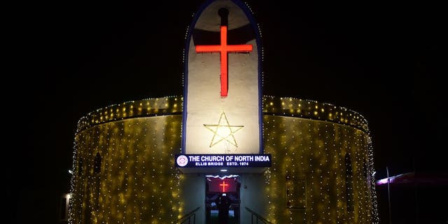 A devotee takes pictures of the illuminated CNI Church ahead of Christmas celebrations in Ahmedabad on December 22, 2021. (Photo by SAM PANTHAKY / AFP) (Photo by SAM PANTHAKY/AFP via Getty Images)