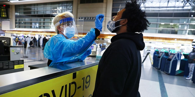 A man receives a nasal swab COVID-19 test at Tom Bradley International Terminal at Los Angeles International Airport amid a coronavirus surge in Southern California on December 22, 2020. (Photo by Mario Tama/Getty Images)