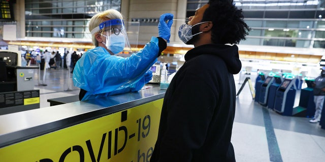 A man receives a nasal swab COVID-19 test at Tom Bradley International Terminal at Los Angeles International Airport amid a coronavirus surge in Southern California on December 22, 2020. (Photo by Mario Tama/Getty Images)