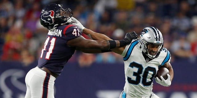 Chuba Hubbard (30) of the Carolina Panthers tries to hold off the tackle of Zach Cunningham (41) of the Houston Texans during a first half run at NRG Stadium on September 23, 2021 in Houston, Texas.