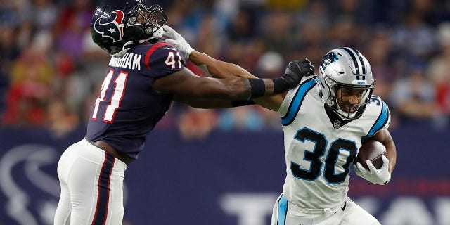 Chuba Hubbard (30) of the Carolina Panthers tries to hold off the tackle of Zach Cunningham (41) of the Houston Texans during a first half run at NRG Stadium on September 23, 2021 in Houston, Texas.