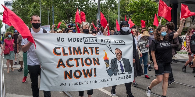Climate change protestors are seen marching and changing as they carry placards on November 06, 2021 in Melbourne, Australia.  (Photo by Asanka Ratnayake/Getty Images)
