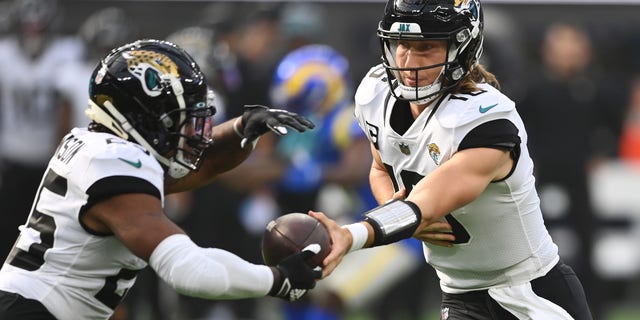 INGLEWOOD, CALIFORNIA - DECEMBER 05: Trevor Lawrence #16 of the Jacksonville Jaguars hands the ball off to James Robinson #25 of the Jacksonville Jaguars during the first quarter against the Los Angeles Rams at SoFi Stadium on December 05, 2021 in Inglewood, California. 