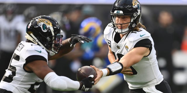 INGLEWOOD, CALIFORNIA - DECEMBER 05: Trevor Lawrence #16 of the Jacksonville Jaguars hands the ball off to James Robinson #25 of the Jacksonville Jaguars during the first quarter against the Los Angeles Rams at SoFi Stadium on December 05, 2021 in Inglewood, California.