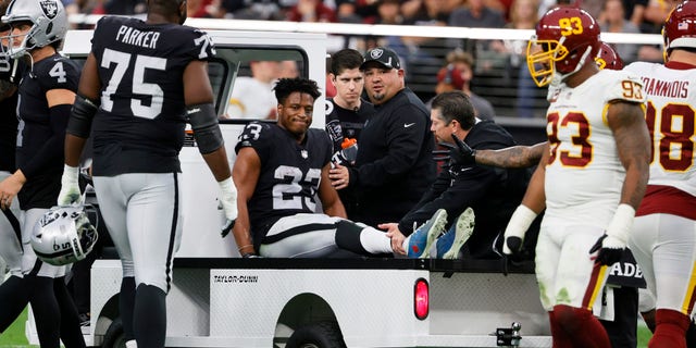 Running back Kenyan Drake #23 of the Las Vegas Raiders is taken off the field on a cart after he was injured on a play against the Washington Football Team during their game at Allegiant Stadium on Dec. 5, 2021 라스 베이거스, 네바다. The Washington Football Team defeated the Raiders 17-15.