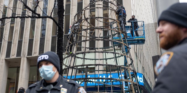 Workers disassemble the Christmas tree outside News Corporation at Fox Square after an arsonist lit the tree on fire Dec. 8, 2021 在纽约市.