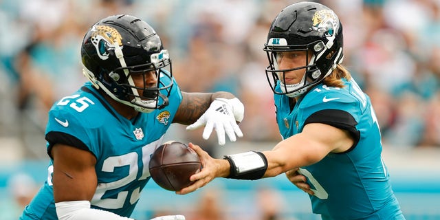Trevor Lawrence (16) of the Jacksonville Jaguars hands the ball to James Robinson (25) during the first quarter against the Houston Texans at TIAA Bank Field Dec. 19, 2021, in Jacksonville, Fla. 
