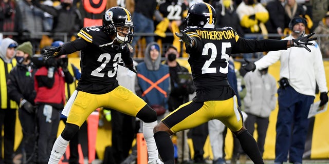 Ahkello Witherspoon #25 and Joe Haden #23 of the Pittsburgh Steelers celebrate a stop on fourth down in the fourth quarter to end the game at Heinz Field on December 19, 2021 in Pittsburgh, Pennsylvania. 