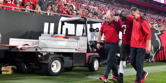 Leonard Fournette #7 of the Tampa Bay Buccaneers is helped off the field after an injury during the quarter of the game against the New Orleans Saints at Raymond James Stadium on Dec. 19, 2021 in Tampa, Florida. 
