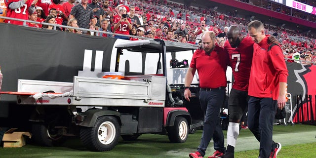 Leonard Fournette #7 of the Tampa Bay Buccaneers is helped off the field after an injury during the quarter of the game against the New Orleans Saints at Raymond James Stadium on Dec. 19, 2021 in Tampa, Florida.