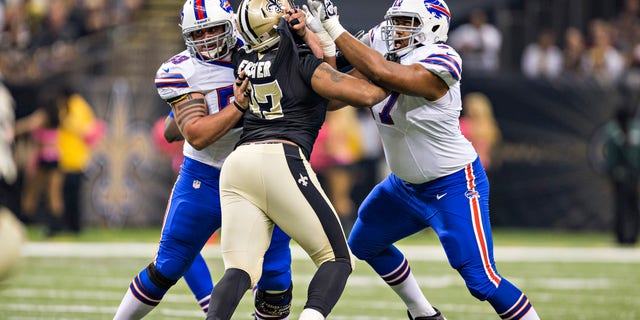 Doug Legursky, #59, and Cordy Glenn, #77 of the Buffalo Bills, blocks Glenn Foster, #97 of the New Orleans Saints, at Mercedes-Benz Superdome on Oct. 27, 2013 in New Orleans. The Saints defeated the Bills 35-14.