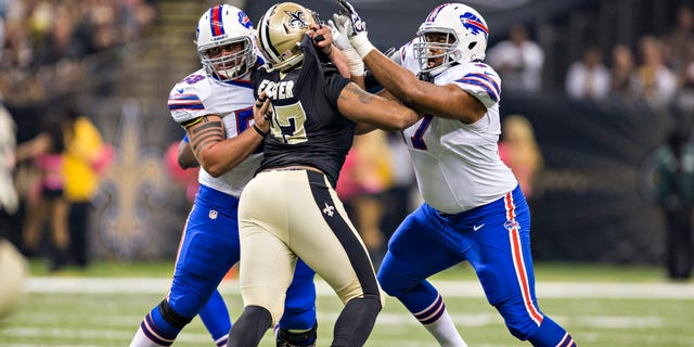 Doug Legursky, #59, and Cordy Glenn, #77 of the Buffalo Bills, blocks Glenn Foster, #97 of the New Orleans Saints, at Mercedes-Benz Superdome on Oct. 27, 2013 in New Orleans. The Saints defeated the Bills 35-14.