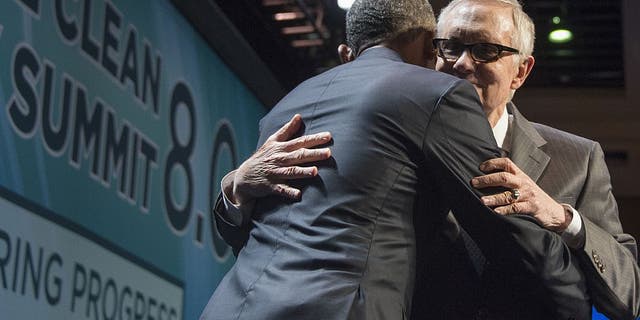 Former President Barack Obama hugs former Sen. Harry Reid before speaking during the National Clean Energy Summit 8.0 in Las Vegas, Nevada, Aug. 24, 2015. (Photo by JIM WATSON/AFP via Getty Images)