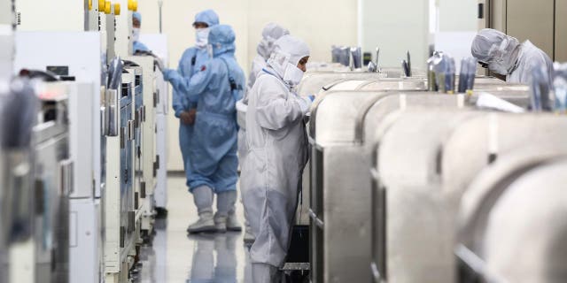 Employees work inside a Siliconware Precision Industries Co. facility in Hsinchu, Taiwan, on Monday, April 18, 2016. 