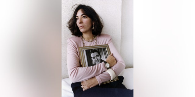 Ghislaine Maxwell, youngest child of media proprietor and fraudster, Robert Maxwell (1923 - 1991), holding a framed photograph of her late father, circa 1991.