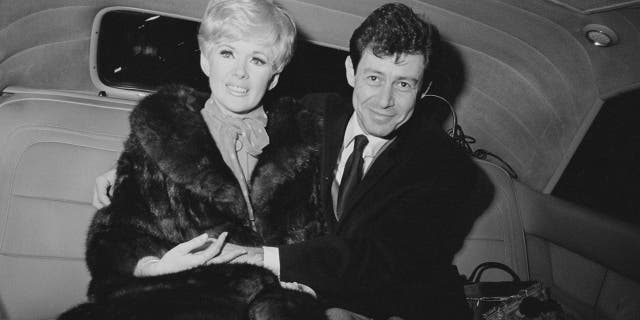 American singer and actor Eddie Fisher (1928 - 2010) with his fiancée, American actress, singer and producer Connie Stevens, sitting in the back of a car after announcing their engagement circa 1967.