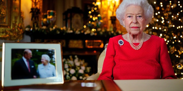 Queen Elizabeth II records her annual Christmas broadcast in the White Drawing Room at Windsor Castle on December 23, 2021, in Windsor, England. The photograph on the desk is of The Queen and the Duke of Edinburgh, taken in 2007 at Broadlands, Hampshire, to mark their Diamond Wedding Anniversary.