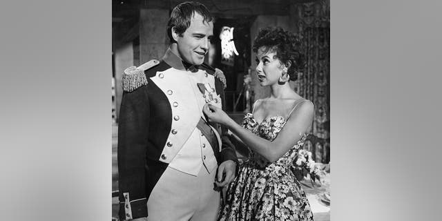 Marlon Brando and Rita Moreno visit on the set of the film 'Desiree', 1954.