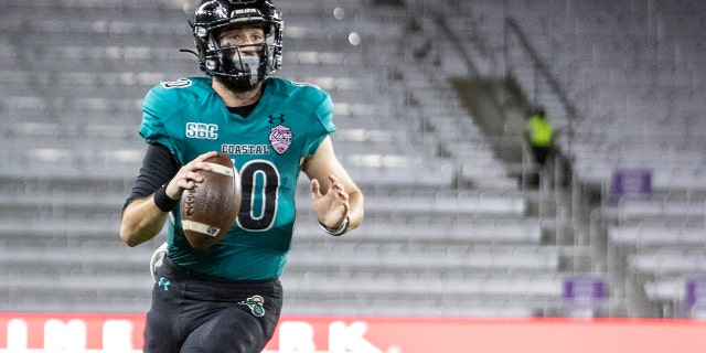 Coastal Carolina quarterback Grayson McCall (10) steps out of the grasp of a Northern Illinois defender during the Cure Bowl in Orlando, Fla., Friday, Dec. 17, 2021.