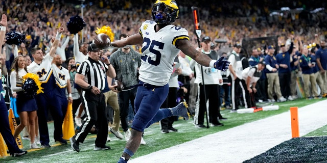 Michigan running back Hassan Haskins (25) celebrates after scoring on a 4-yard touchdown run during the second half of the Big Ten championship NCAA college football game against Iowa, Saturday, Dec. 4, 2021, in Indianapolis.