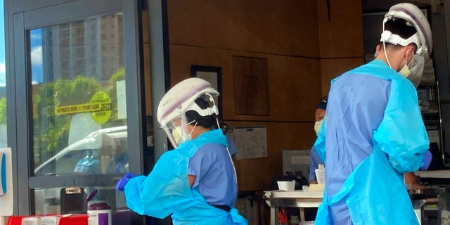 Hospital workers process COVID-19 tests at a hospital in Aiea, Hawaii, Wednesday, Sept. 15, 2021. (AP Photo/Caleb Jones)