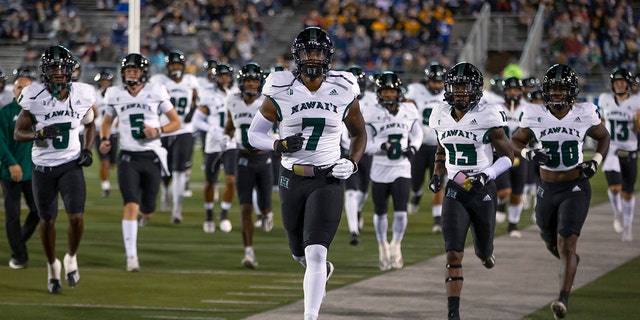 FILE - The Hawaii team takes the field before an NCAA college football game against Nevada in Reno, Nev., Oct. 16, 2021. The Hawaii Bowl was canceled Thursday, Dec. 23, on the eve of the game after Hawaii withdrew because of COVID-19, season-ending injuries and transfers.