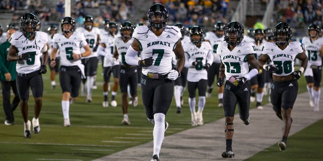 文件 - The Hawaii team takes the field before an NCAA college football game against Nevada in Reno, Nev., 十月. 16, 2021. The Hawaii Bowl was canceled Thursday, 十二月. 23, on the eve of the game after Hawaii withdrew because of COVID-19, season-ending injuries and transfers.