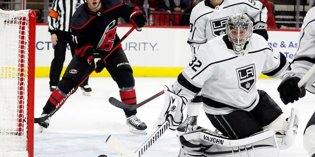Los Angeles Kings goaltender Jonathan Quick (32) deflects a shot with Carolina Hurricanes' Jesper Fast (71) and teammate Sean Durzi (50) looking on during the second period of an NHL hockey game in Raleigh, N.C., Sabato, Dic. 18, 2021.