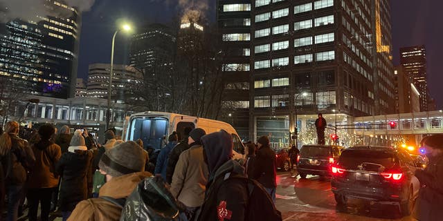 A person stands on a car near the Hennepin County Courthouse in Minneapolis Wednesday during a protest demanding "Justice for Daunte Wright."