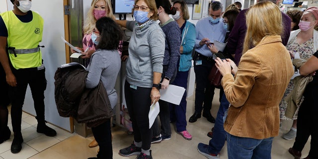 Staff volunteers line up to receive a fourth dose of the Pfizer-BioNTech COVID-19 coronavirus vaccine at the Sheba Medical Center in Ramat Gan near Tel Aviv, on December 27, 2021. (Photo by JACK GUEZ / AFP) (Photo by JACK GUEZ/AFP via Getty Images)