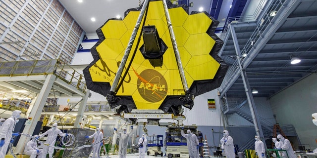 In deze afbeelding van 13 april 2017, geleverd door NASA, tillen technici de spiegel van de James Webb Space Telescope op met behulp van een kraan in het Goddard Space Flight Center in Greenbelt, Maryland.