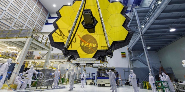 In deze afbeelding van 13 april 2017, geleverd door NASA, tillen technici de spiegel van de James Webb Space Telescope op met behulp van een kraan in het Goddard Space Flight Center in Greenbelt, Maryland.