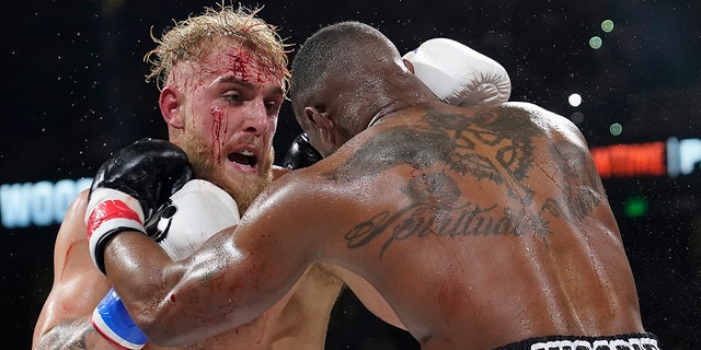 Jake Paul, left, punches Tyron Woodley during the third round of a Cruiserweight fight Sunday, Dec. 19, 2021, in Tampa, Fla.