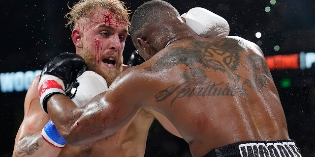 Jake Paul, left, punches Tyron Woodley during the third round of a Cruiserweight fight Sunday, Dec. 19, 2021, in Tampa, Fla.