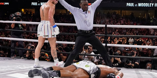 Jake Paul, izquierda, looks back after knocking out Tyron Woodley during the sixth round of a Cruiserweight fight Sunday, dic. 19, 2021, in Tampa, Fla.