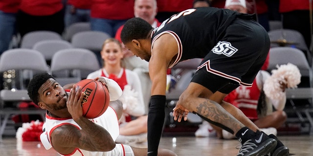 Houston guard Jamal Shead prepares to make a pass in front of Oklahoma State's Rondel Walker, 对, after grabbing a loose ball on the court in the second half of an NCAA college basketball game in Fort Worth, 德州, 星期六, 十二月. 18, 2021.