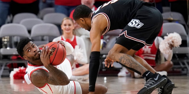Houston guard Jamal Shead prepares to make a pass in front of Oklahoma State's Rondel Walker, 对, after grabbing a loose ball on the court in the second half of an NCAA college basketball game in Fort Worth, 德州, 星期六, 十二月. 18, 2021.