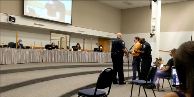 Jeremy Story getting escorted out of a Round Rock ISD school board meeting.