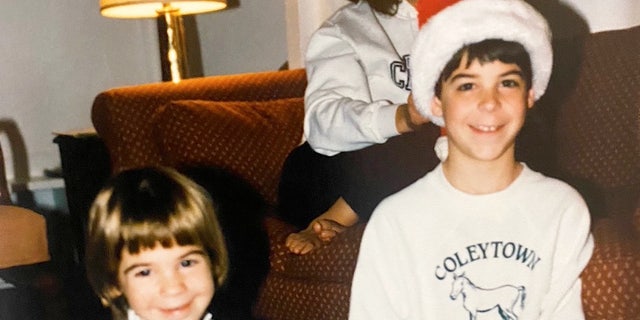 A young Jesse Watters (권리) is shown with his sister, Aliza, opening gifts at Christmas. 어린 시절, he remembers going door-to-door to sing Christmas carols for neighbors and friends. 