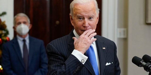 President Biden speaks about the COVID-19 variant named omicron, in the Roosevelt Room of the White House, Monday, Nov. 29, 2021, in Washington. as Dr. Anthony Fauci, director of the National Institute of Allergy and Infectious Diseases listens. 