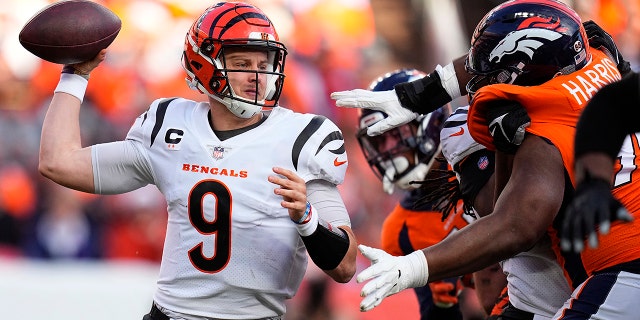 Cincinnati Bengals quarterback Joe Burrow (9) throws under pressure from Denver Broncos defensive end Shelby Harris during the first half of an NFL football game, Sunday, Dec. 19, 2021, in Denver.